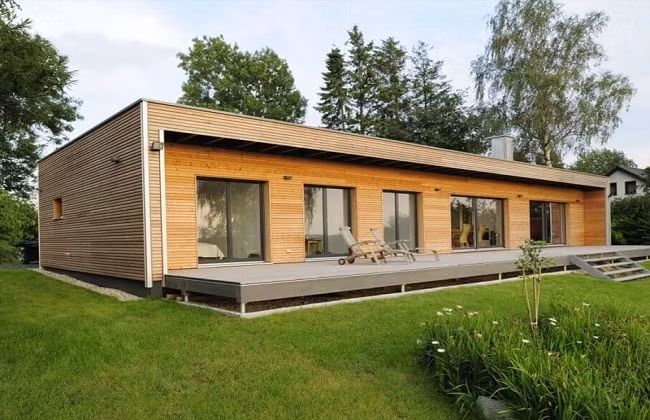 Mẫu nhà gỗ cấp 4 mái bằng hiện đại không sử dụng các cột tròn như nhà gỗ truyền thống. Nhà có không gian mở, sử dụng nhiều cửa kính và các chi tiết trang trí cũng chỉ là những đường nét, hình khối thẳng đơn giản được kết hợp tinh tế