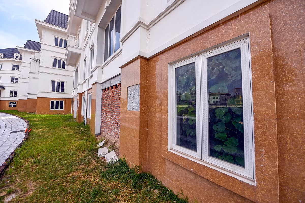 Lối ra vào của nhiều căn biệt thự được tạm thời xây kín lại bằng gạch, phía bên trong nhà cỏ dại mọc um tùm.