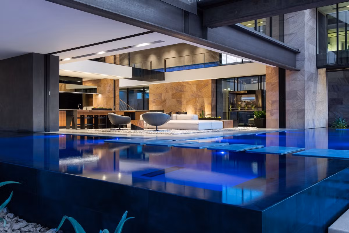 Không gian thư giãn ngoài trời bao gồm 3 hồ bơi, bồn ngâm nước nóng, bếp và bàn ăn.