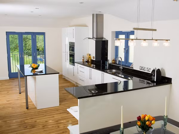 Căn bếp nổi bật nhờ sự tương phản giữa hai màu chủ đạo đen – trắng và nét nhấn nhá từ những ô cửa màu xanh lam. Không gian tinh tươm, sáng loáng, mang đến những bữa ăn ngon miệng