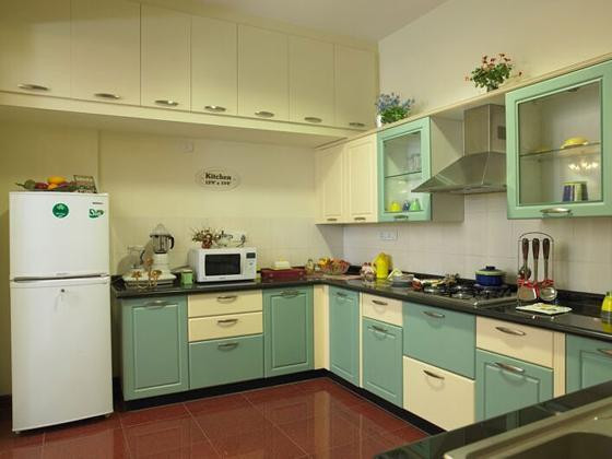 Sắc xanh từ hệ tủ bếp hình chữ L khiến căn bếp có điểm nhấn về thị giác