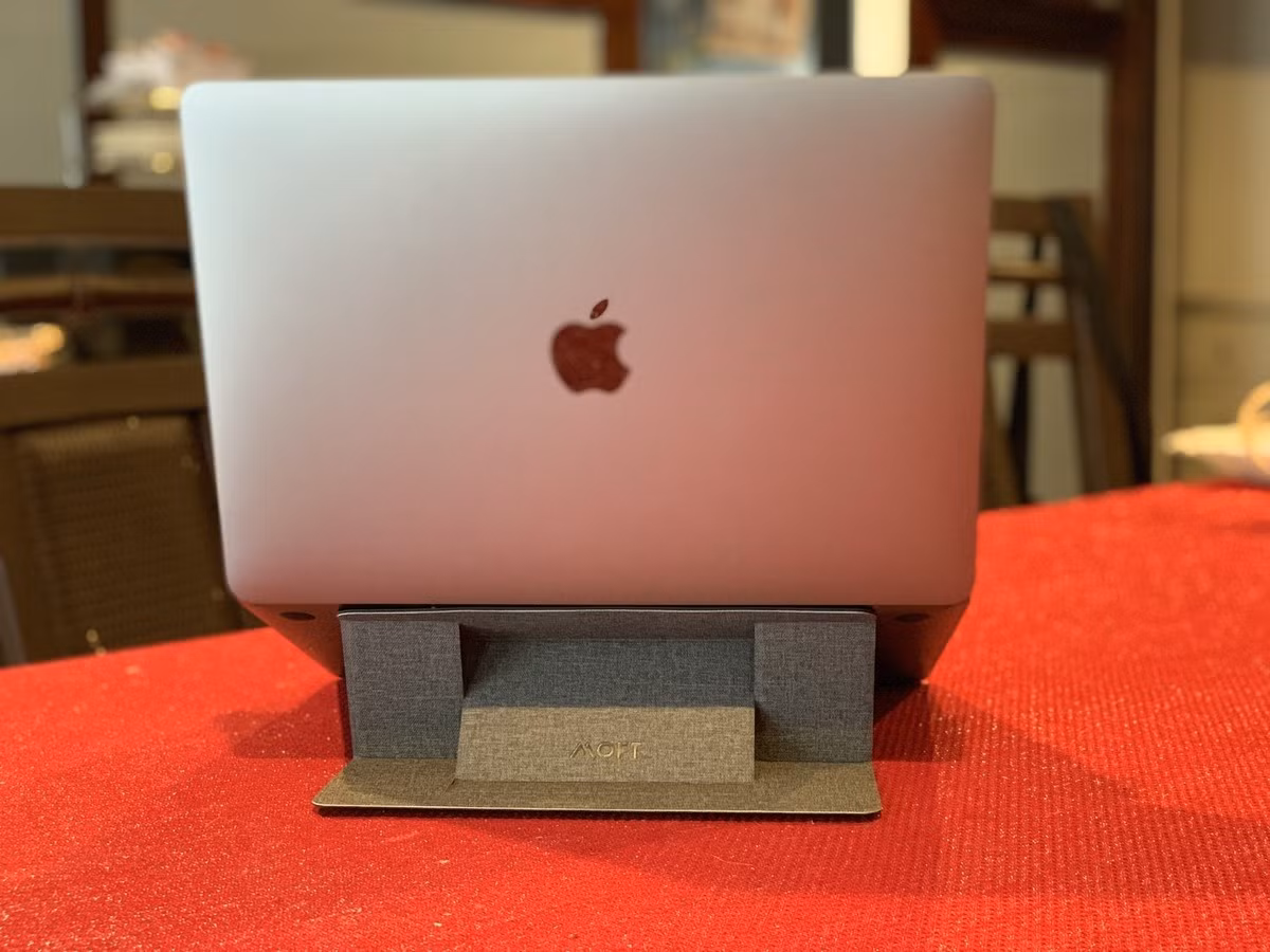  MOFT X Laptop Stand hỗ trợ nâng laptop lên góc nghiêng 15 hoặc 25 độ, tạo cảm giác thoải mái khi gõ phím trong thời gian dài. Sản phẩm được dán bên dưới với độ mỏng 3 mm, nặng 89 g nên không ảnh hưởng lớn đến độ dày của máy. Tuy nhiên, người dùng laptop có khe tản nhiệt bên dưới nên chú ý khi mua sản phẩm. Giá bán của MOFT X Laptop Stand khoảng 290.000-420.000 đồng, tùy phiên bản không hoặc có lỗ thoát nhiệt. Ảnh: iMore.