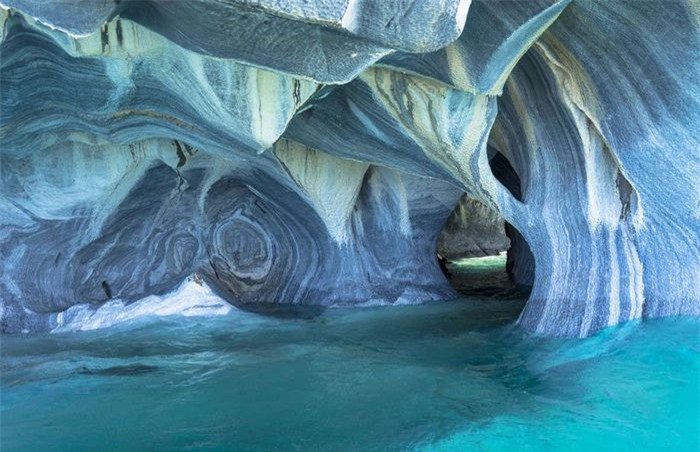 Hang đá cẩm thạch, Chile:Nhiều du khách khi khám phá mạng lưới hang động nằm dưới hồ General Carrera, Chile, đã đánh giá đây là nơi "đẹp nhất thế giới". Thành hang được tạo ra từ khoáng chất canxi cacbonat, khi thủy triều rút bạn mới có thể khám phá các lối thông bên trong. Năm 1994, hang động được công nhận là Di tích quốc gia của Chile.
