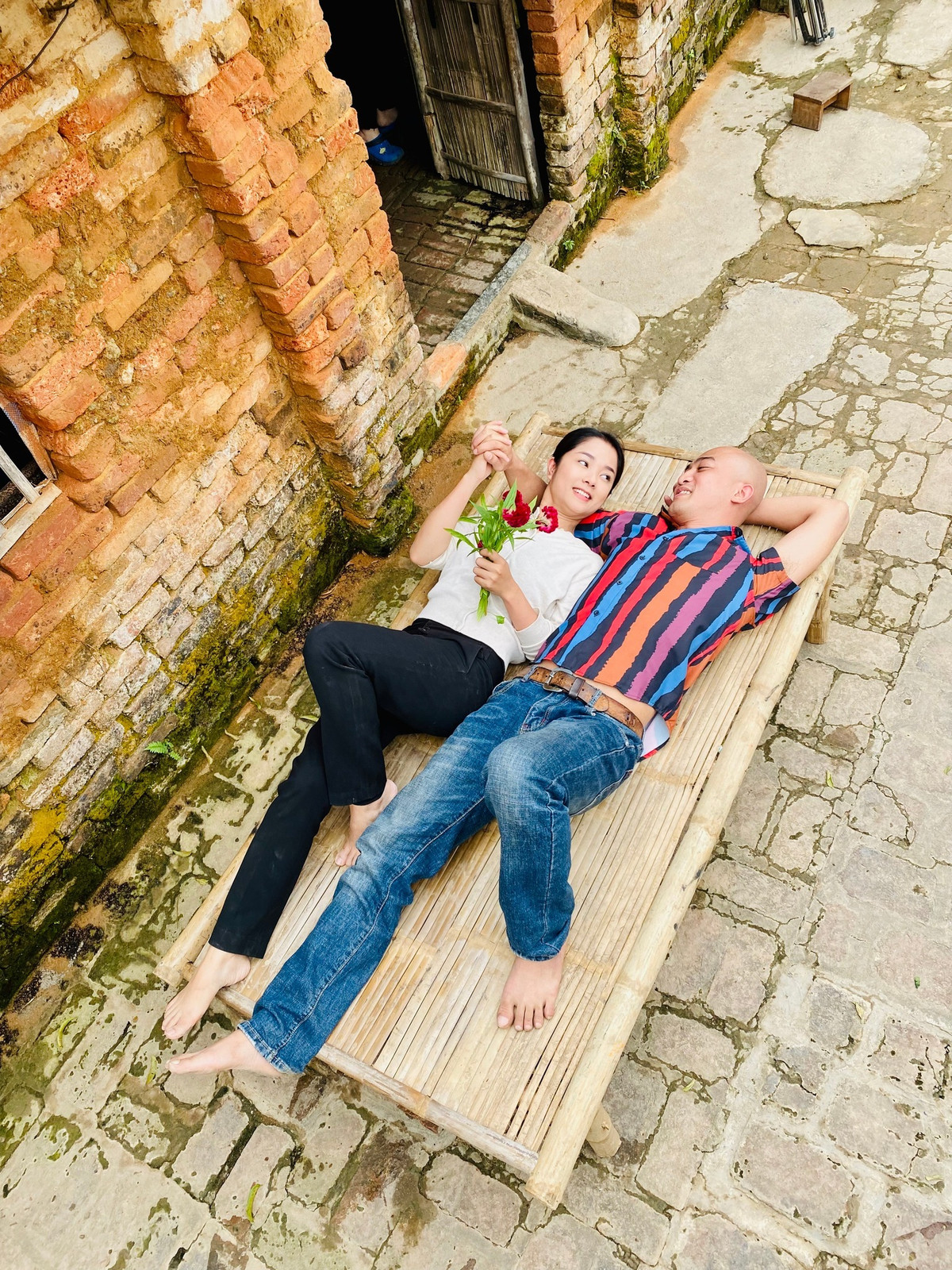 Doãn Quốc Đam cũng vừa chia sẻ loạt ảnh chụp cùng người vợ màn ảnh trên một chiếc chõng che ở bối cảnh phim khiến nhiều khán giả thích thú.