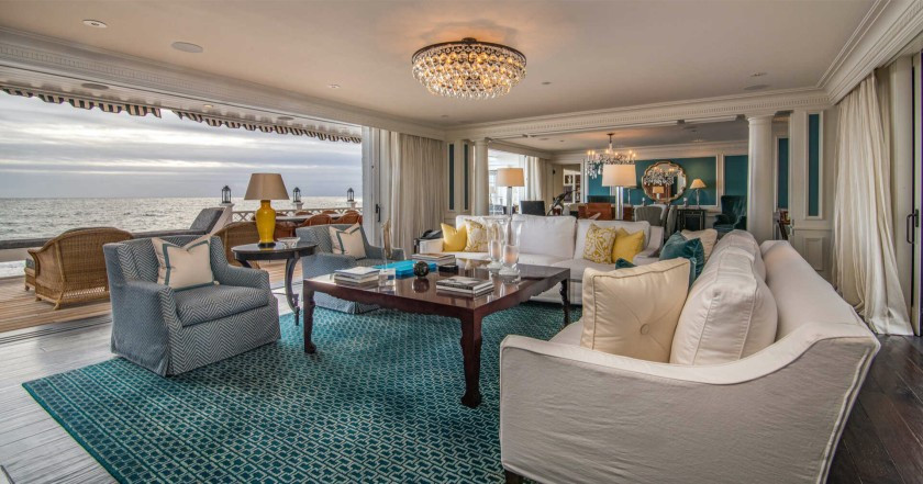 Phòng khách rộng lớn, thoáng đãng, có tầm nhìn ra đại dương. Sát phòng khách là một hiên nhà lát gỗ mang vẻ đẹp mộc mạc.