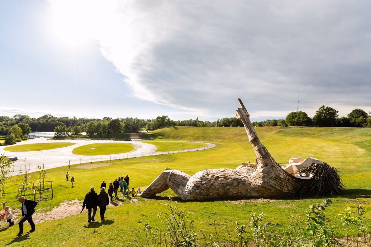 Thomas Dambo được biết đến với các tác phẩm điêu khắc ngoài trời ngoạn mục, mô tả những con quỷ khổng lồ trong thần thoại, tất cả đều được làm từ rác và gỗ tái chế. Trước công trình nghệ thuật ở Bỉ này, Dambo hợp tác chế tạo nhiều tác phẩm ở Copenhagen, Hàn Quốc, Puerto Rico và Mỹ.