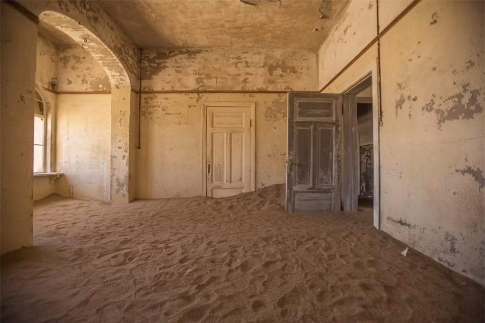 Một ngôi làng khai thác mỏ ở Kolmanskop, Namibia, nơi mà ranh giới giữa trong nhà và ngoài trời biến mất, khi cát ngập vào tận bên trong.