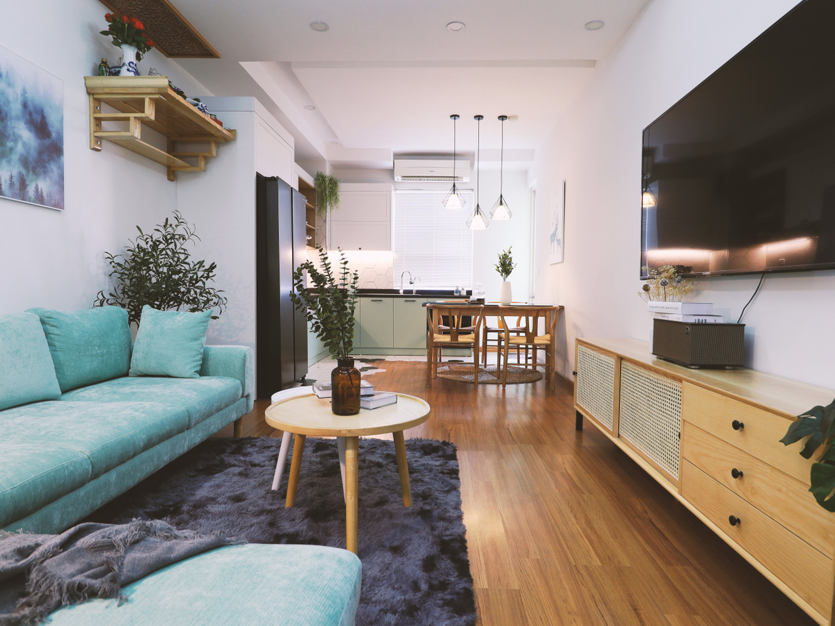 Căn hộ sau cải tạo mang phong Scandinavian (Bắc Âu) với nội thất tối giản, màu sắc chủ đạo là xanh lá cây kết hợp màu gỗ ấm. "Phong cách này khá phù hợp với các căn hộ chung cư có diện tích trung bình, thiết kế nội thất không cầu kỳ, ít chi tiết, mang đến cảm giác căn hộ rộng rãi hơn", anh Quyền nói.