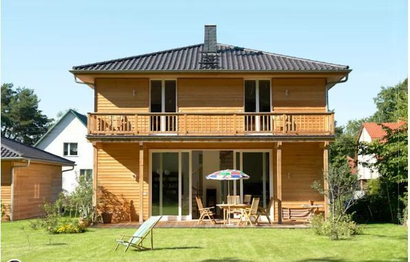 Căn nhà gỗ sáng màu với thiết kế đơn giản, tinh tế từ sân vườn cho đến hiên nhà tạo nên một vẻ đẹp thu hút, nổi bật dưới ánh nắng rực rõ