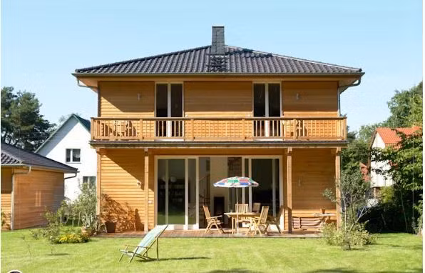 Căn nhà gỗ sáng màu với thiết kế đơn giản, tinh tế từ sân vườn cho đến hiên nhà tạo nên một vẻ đẹp thu hút, nổi bật dưới ánh nắng rực rõ