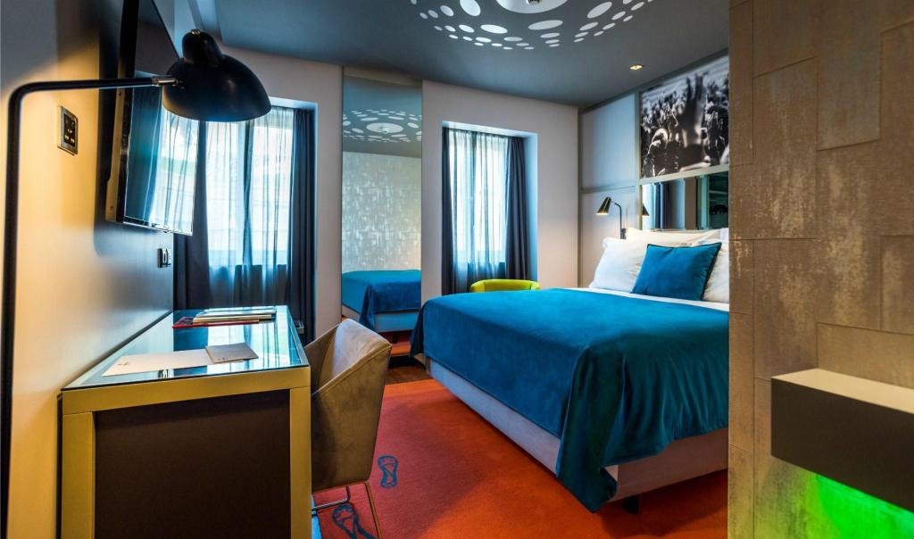 Khách sạn có 82 phòng với nhiều mức giá khác nhau, từ 158 USD/đêm. Phòng ngủ tone xanh lá cây và xám chủ đạo, nổi bật với tấm thảm họa tiết 7 dấu chân Ronaldo, bức ảnh khán giả cổ vũ bóng đá đen trắng treo trên tường. Phòng tắm sử dụng đá cẩm thạch và thương hiệu đồ vệ sinh cá nhân của Ronaldo. Một số hạng phòng cao cấp, chẳng hạn như CR7 Suite có bồn tắm với vòi sen. Ảnh: Agoda.