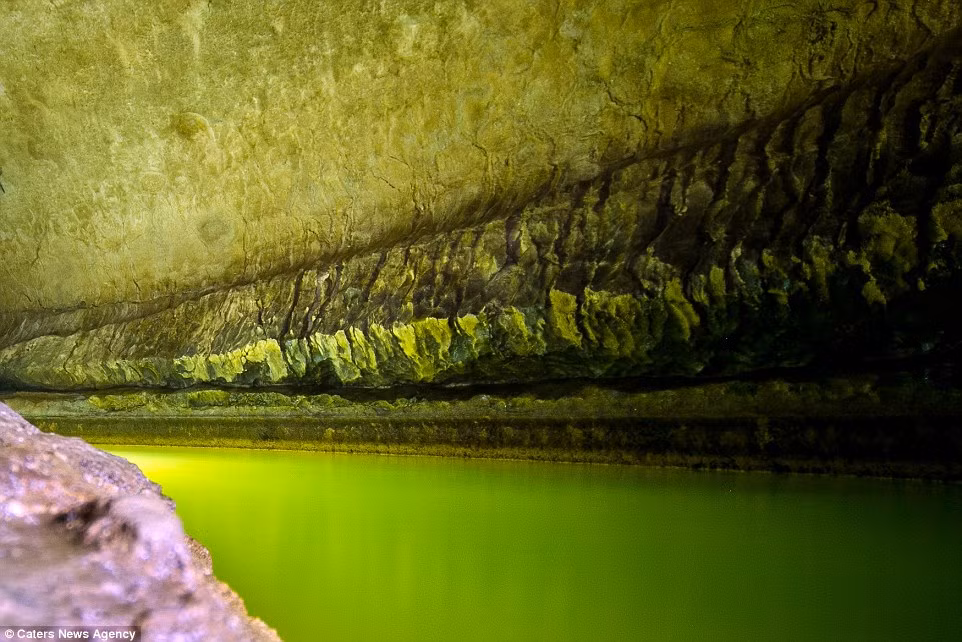 Ánh sáng xanh kỳ quái được tạo ra khi ánh đuốc phản chiếu lên thành hang động.