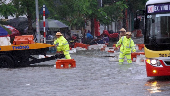 Lực lượng CSGT được huy động tới kéo dải phân cách thoát khỏi nước mưa, chống ùn tắc, hỗ trợ các phương tiện di chuyển.