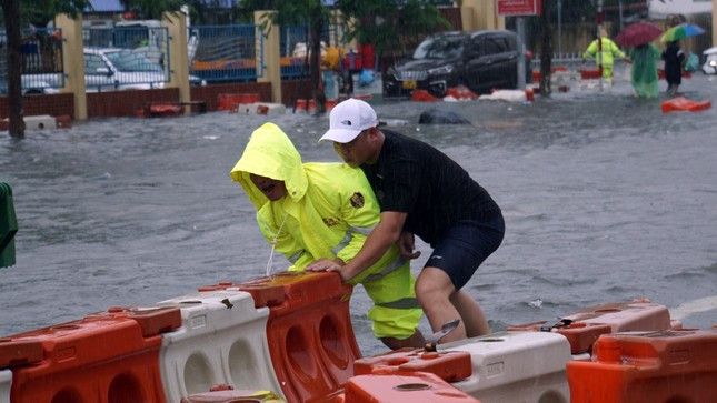 Cảnh sát chật vật di chuyển từng khối dải phân cách bị sóng đánh dạt.