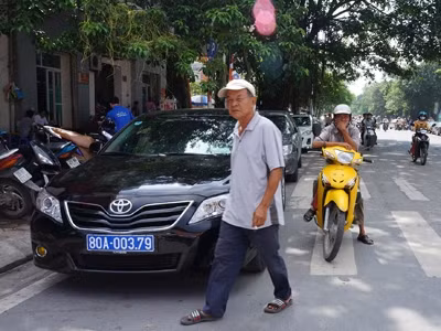 Chiếc xe đỗ dưới lòng đường, chiếm hết vạch sơn dành cho người đi bộ tại đường Trần Hưng Đạo., Hà Nội.