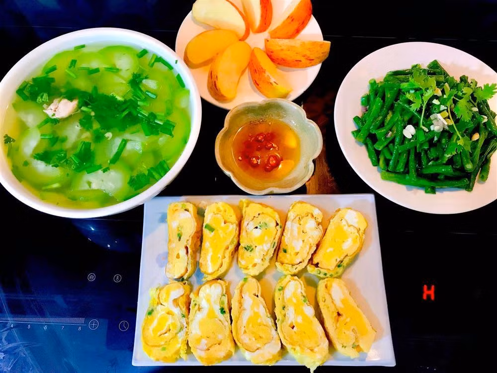 Chị tiết lộ, chi phí các bữa ăn hàng ngày dao động từ 100k đến 200k. Một thực đơn thanh đạm với trứng cuộn, canh bí xanh, đậu đũa xào và tráng miệng táo. Các món ăn trông đầy ú ụ là vậy nhưng đều được cả nhà "xử lý" sạch bách mỗi ngày. Bí quyết của chị Tình rất đơn giản: Hãy ưu tiên chọn đồ tươi sống và kết hợp đúng nguyên liệu. Chẳng hạn kho cá phải có riềng, sả, nghệ. Các món rau phải đun lửa to để giữ độ xanh và tươi.