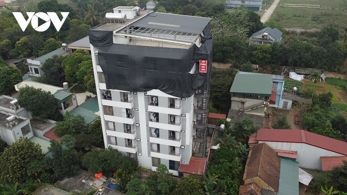 Tầng trên phủ lưới đen, bên dưới là những căn hộ đang có người sử dụng.