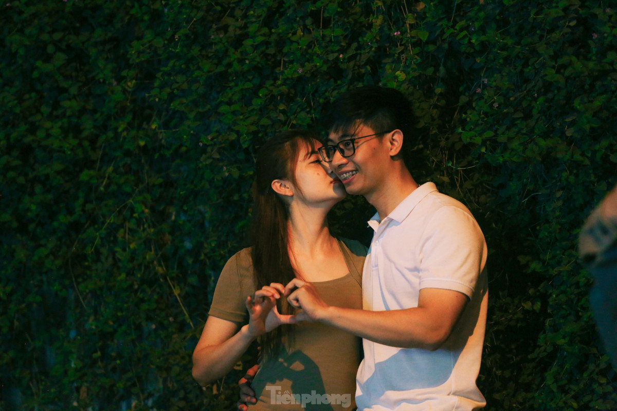 Cặp đôi tranh thủ ghi lại khoảnh khắc tại con đường hoa tím ngũ sắc.