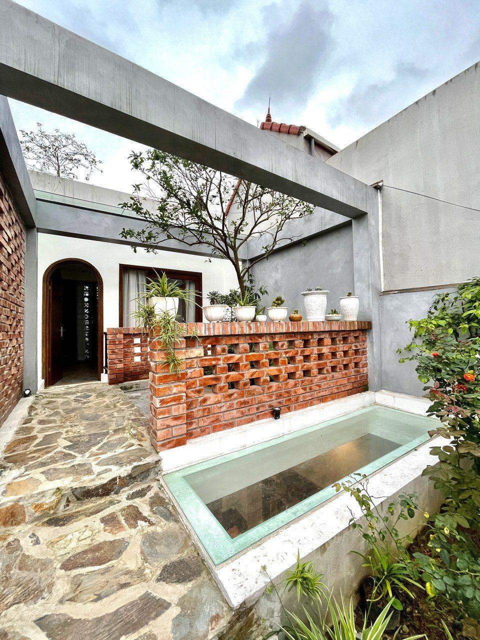 Giếng trời nằm ở vườn tầng 2, thông với phòng khách. Lối đi ra vườn ốp đá rối Lai Châu.