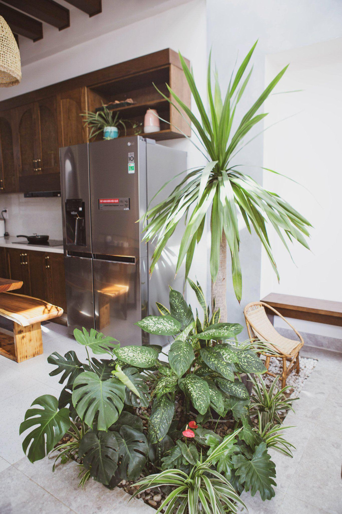 Dù là nhà nhỏ hay to, nhóm luôn cố gắng đưa thiên nhiên vào không gian sống. Giếng trời thông lên khu sân vườn, sử dụng mái kính để lấy ánh sáng cho phòng khách. Cây xanh được trồng trực tiếp dưới nền nhà. Anh Việt Đức chia sẻ, để trồng được như vậy mà không ảnh hưởng đến móng nhà và thấm nước, ngay từ khi bắt đầu làm móng, anh đã để chừa ra 1 ô, xử lý chống thấm, sau đó mới đổ đất vào.