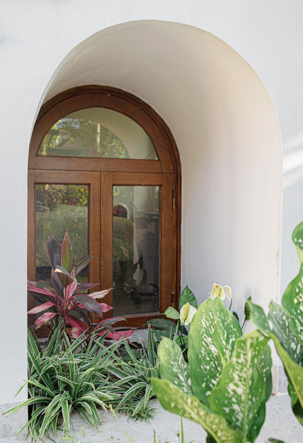 Cửa sổ nằm dưới gầm cầu thang, tạo hình vòm khiến ta liên tưởng đến khu hầm bí mật rất thú vị.