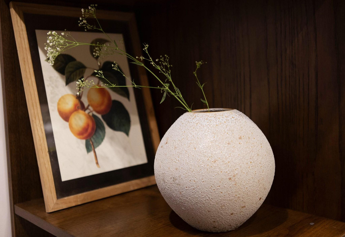 Sắc cam được nhấn trong đệm ghế và tranh decor làm không gian sinh động, nổi bật.