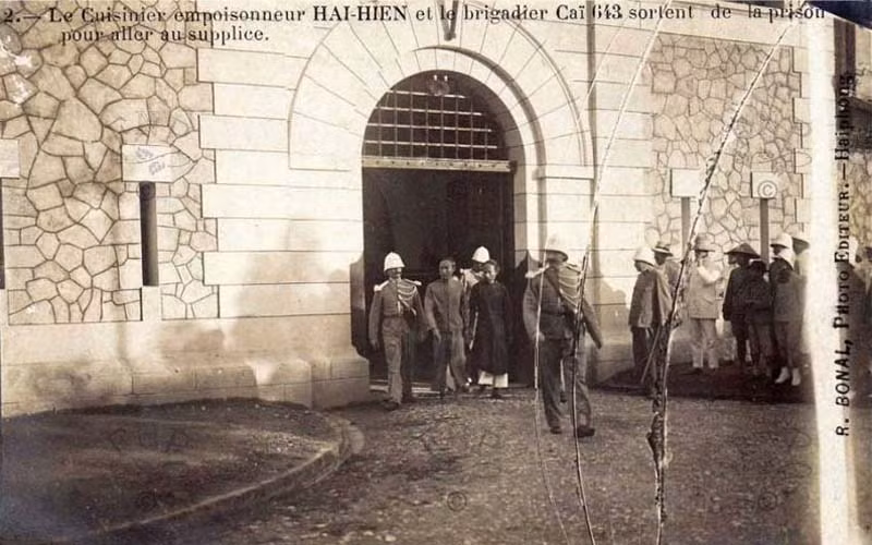 Đầu bếp Hai Hiên (mặc áo dài đen) và đồng phạm trong vụ Hà Thành đầu độc đang rời nhà tù Hỏa Lò để đến nơi hành hình, 6/8/1908. Ảnh: Manhhai / Flickr.