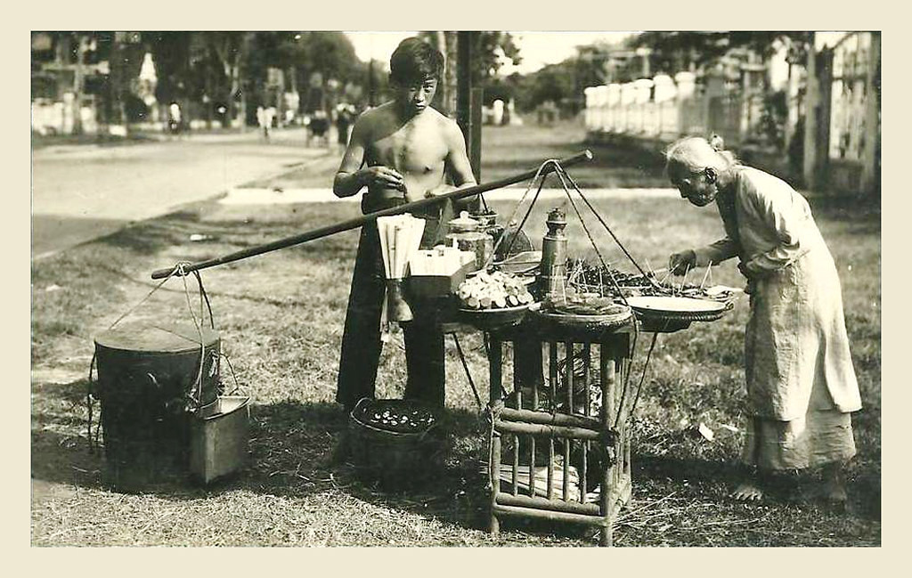 Cụ bà chọn món ăn tại gánh hàng rong của một thanh niên. Ảnh: manhhai / Flickr.