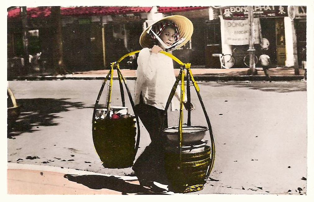 Người phụ nữ mưu sinh trên đường phố Sài Gòn với gánh hàng trĩu nặng trên vai. Ảnh: manhhai / Flickr.