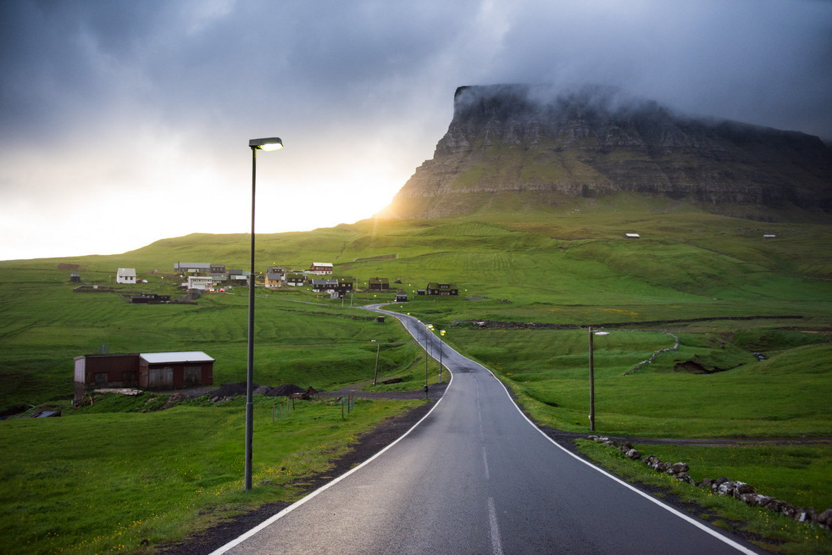 Về phía Bắc của ngôi làng là núi Árnafjall cao 722 mét, là ngọn núi cao nhất đảo. Còn về phía đông là núi Eysturtindur cao 715 mét, cao thứ hai trên đảo. Ảnh: Tom Archer.