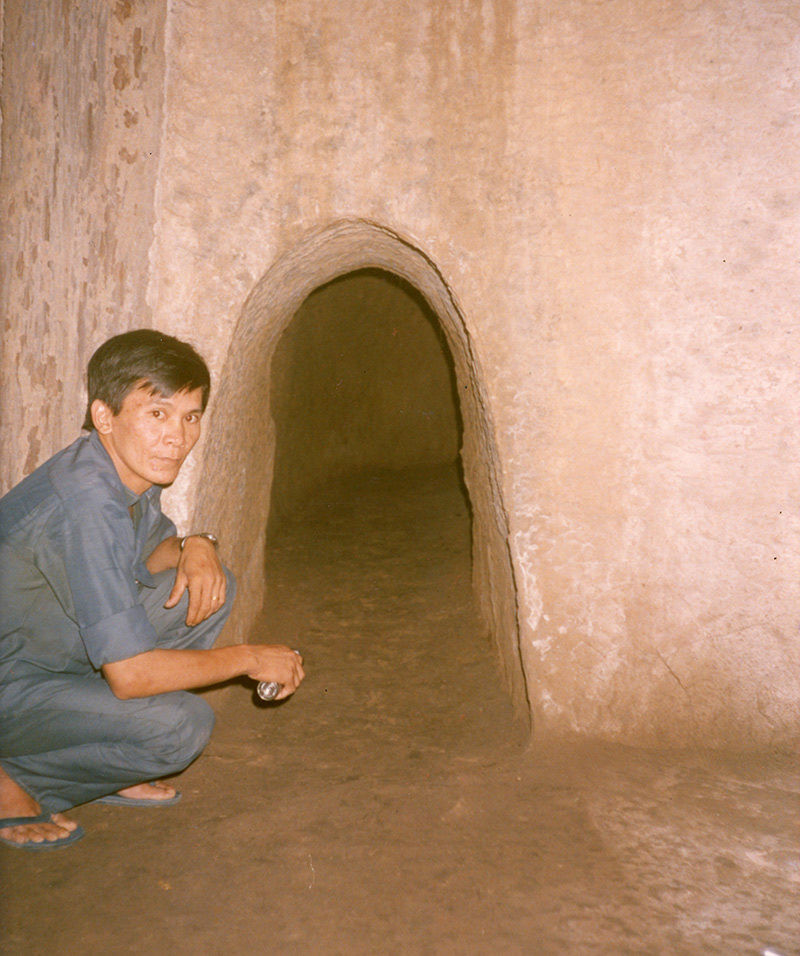 Bên trong một đoạn đường hầm ở địa đạo Củ Chi. Hướng dẫn viên là một cựu chiến binh giải phóng từng hoạt động ở địa đạo. Ảnh: Marc Yablonka / SFA 78.