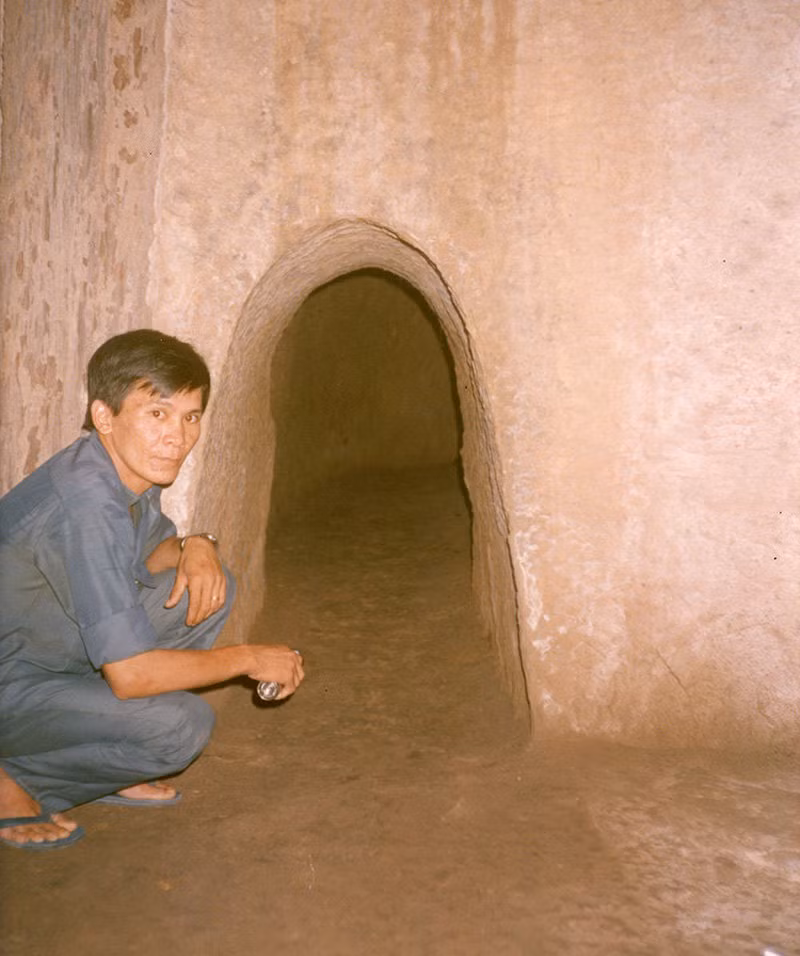 Bên trong một đoạn đường hầm ở địa đạo Củ Chi. Hướng dẫn viên là một cựu chiến binh giải phóng từng hoạt động ở địa đạo. Ảnh: Marc Yablonka / SFA 78.