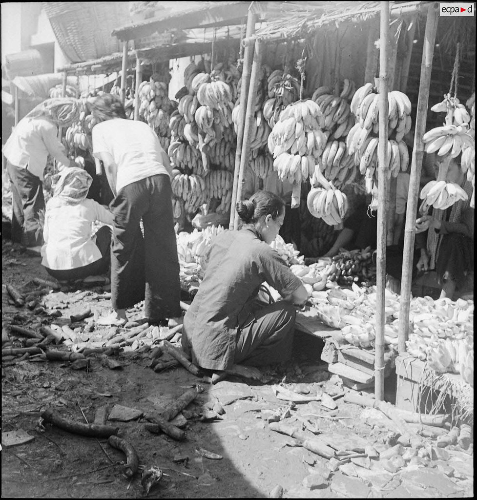 Người dân lựa chuối ở chợ. Ảnh: Auteur inconnu/ECPAD/Défense.