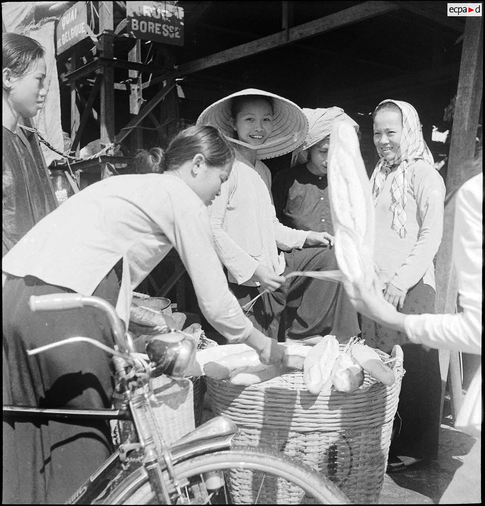 Cô gái mua bánh mì. Ảnh: Auteur inconnu/ECPAD/Défense.