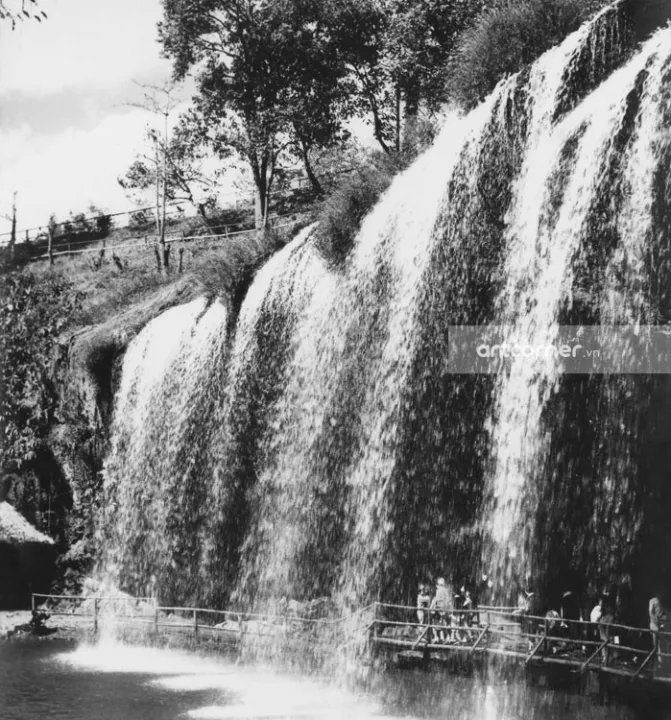 Du khách khám phá thác Prenn bằng lối đi bằng gỗ bên dưới thác, 1954. Ảnh: Artcorner.vn.