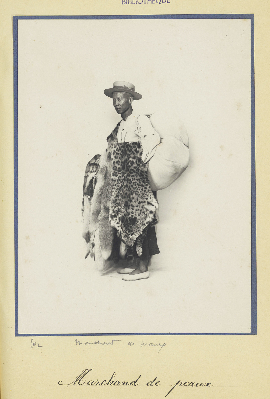 Người bán da thú với bộ da báo và da nhiều loài thú rừng khác trên tay.