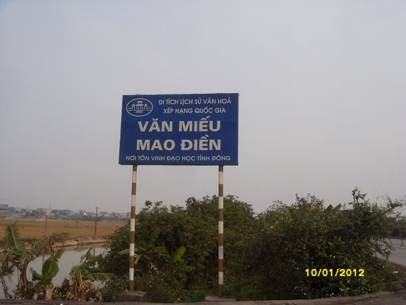Văn Miếu Mao Điền được khởi dựng bắt đầu vào những năm đầu thế kỷ 15 thời Lê Sơ, thuộc Phủ Thượng Hồng, Huyện Đường An, xã Vĩnh Lại (nay là xã Vĩnh Tuy, huyện Bình Giang). Công trình gồm 5 gian Bái đường và 3 gian Chính Tẩm đặt trên một gò đất cao. Đồng thời với Văn Miếu là trường thi Hương của trấn Hải Dương, được xây dựng tại xã Mao Điền, huyện Cẩm Giàng. Hai công trình này nằm cách nhau khoảng 1 km theo đường chim bay. Ảnh: Biển chỉ dẫn vào Văn Miếu Mao Điền bên Quốc Lộ 5 thuộc xã Vĩnh Tuy – Bình Giang – Hải Dương.