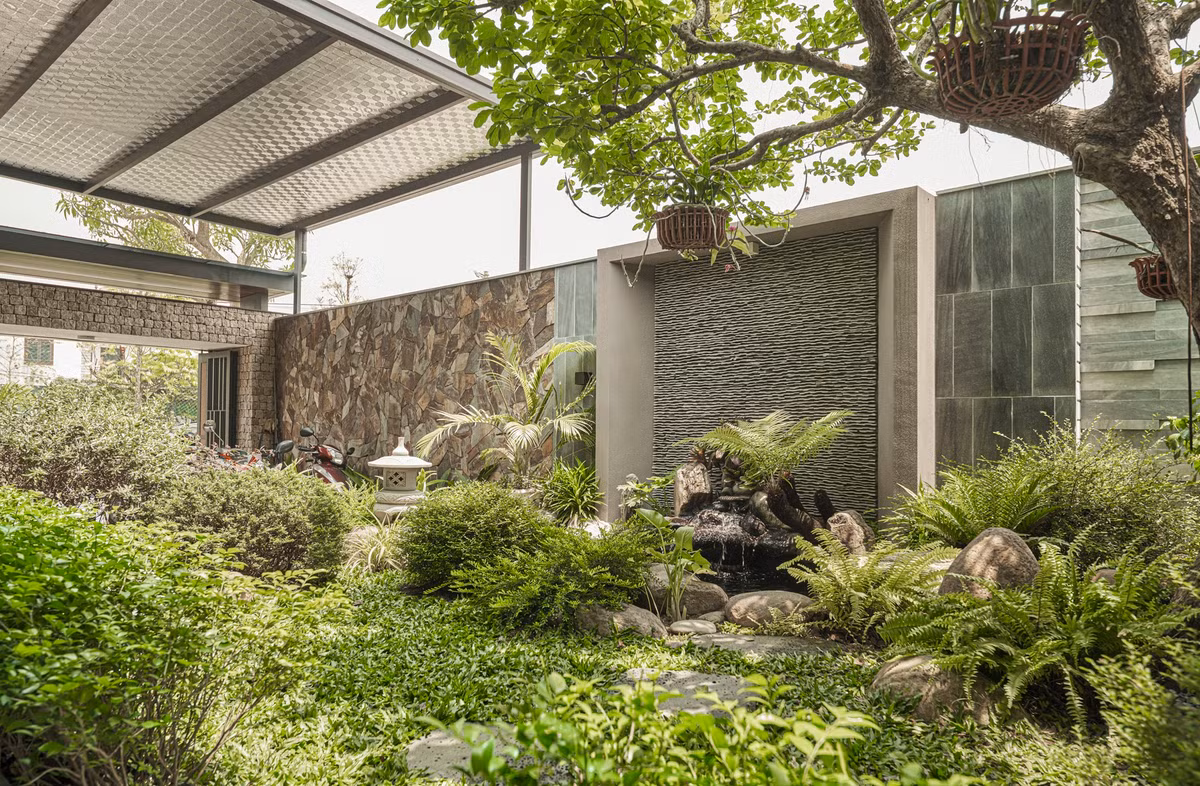 Bước qua cánh cổng là không gian sân vườn xanh mát, gồm nhiều tầng thực vật khác nhau. Đây là nơi người bố thường ngồi ngắm cảnh, tưới cây, chăm hồ cá, hưởng thú vui tuổi già.