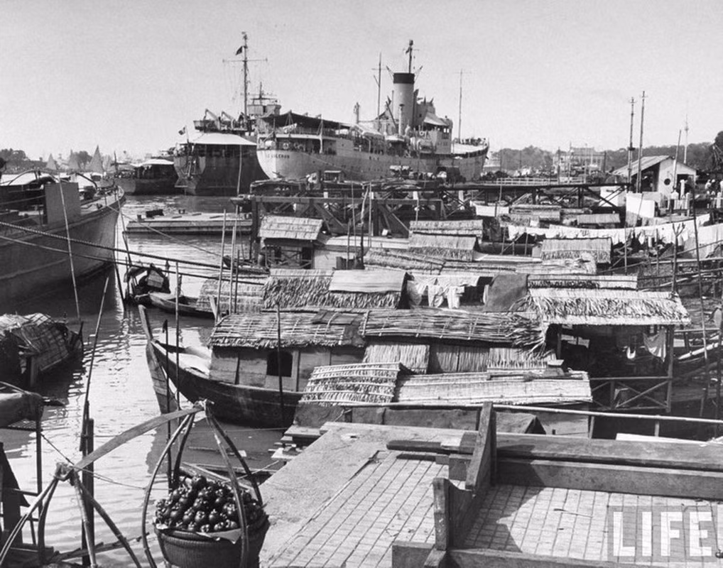 Tàu vận tải Pháp đậu gần những con thuyền lụp xụp của người Việt trên sông Sài Gòn.