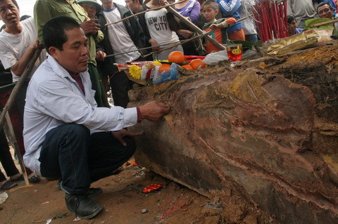 Một người dân hiếu kỳ đã cạy lớp vỏ bên ngoài của quan tài để xem.