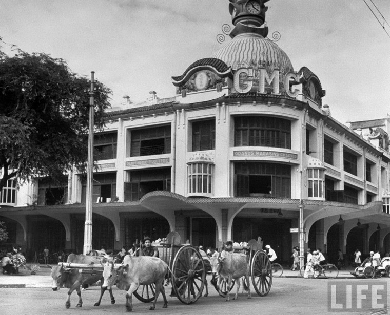 Xe bò kéo chạy qua thương xá Grands Magasins Charner, sau này là thương xá Tax.