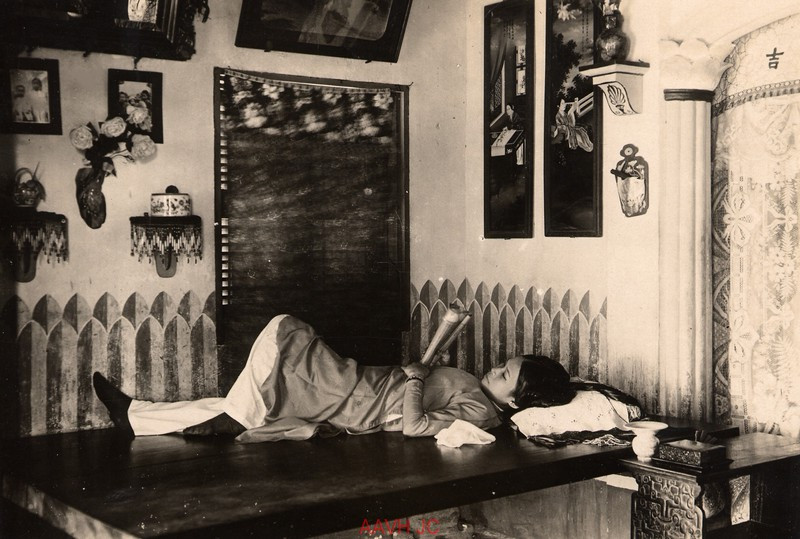 Một tiểu thư nằm đọc sách trên tấm phản tại tư gia ở Huế, 1930.