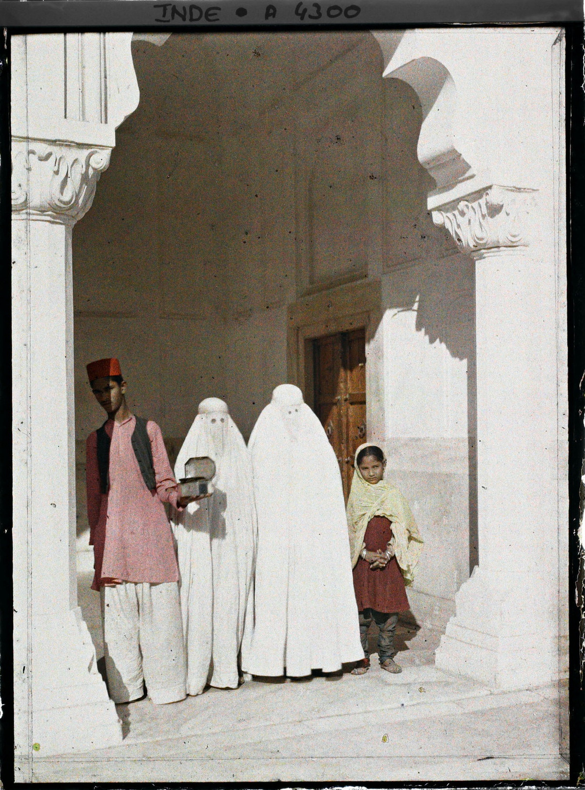 Bé gái, hai người phụ nữ Hồi giáo trùm khăn trắng và người giám hộ tại thánh đường Hồi giáo Ngọc trai (Moti Masjid) trong Pháo đài Đỏ ( Lal Qila).