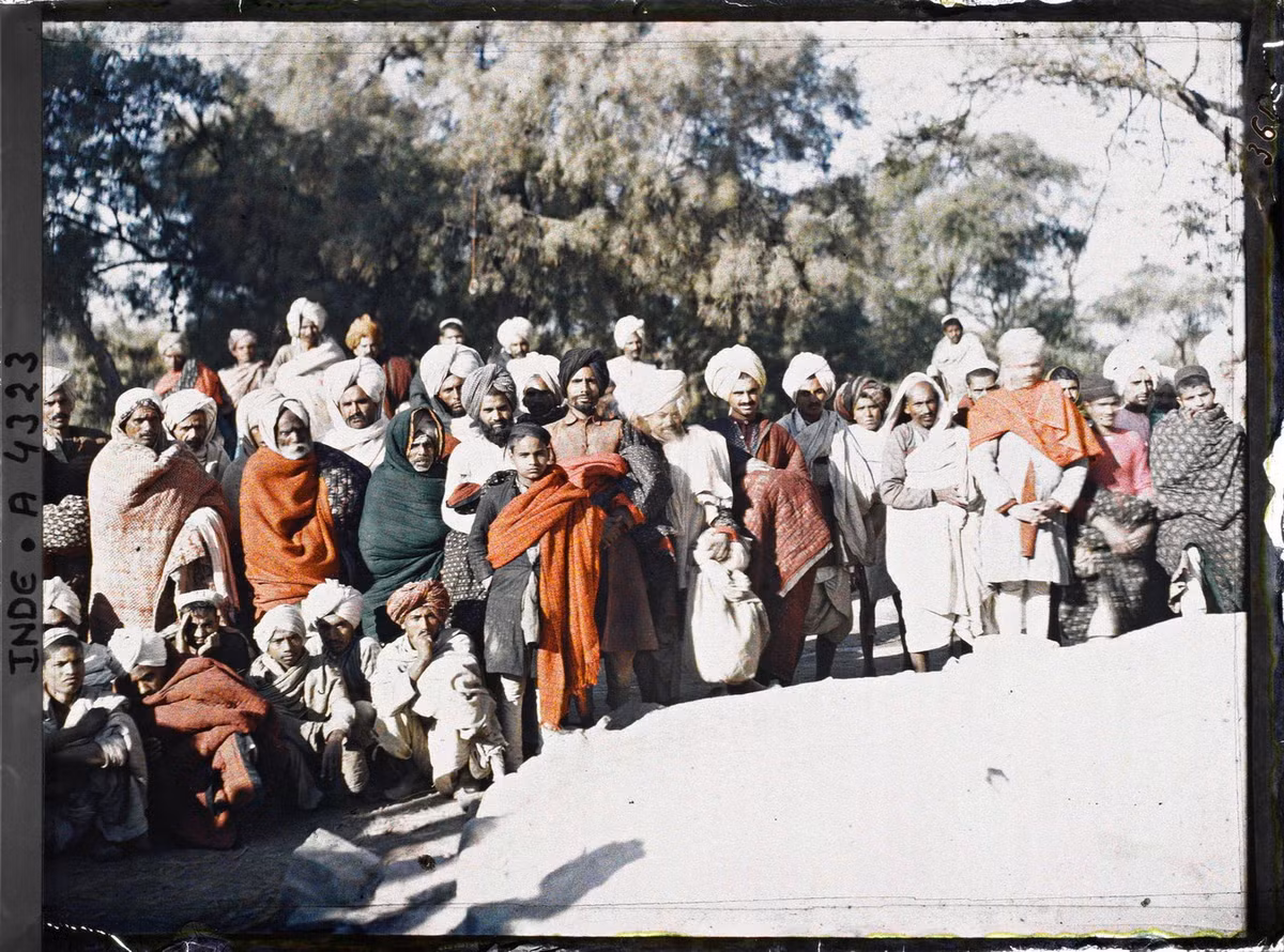 Nhóm tín đồ đạo Hindu và đạo Hồi quây quanh một người được coi là thánh sống (không ở trong khung hình).