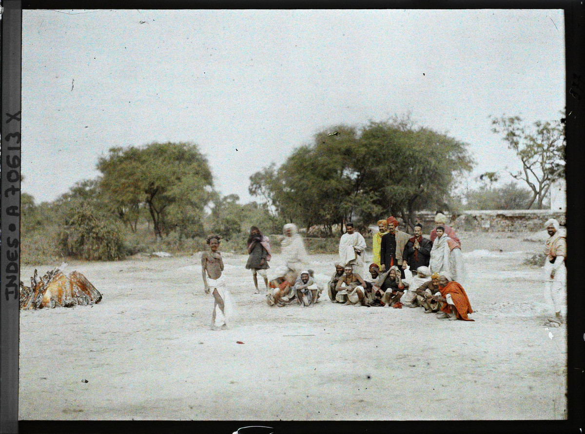 Những người đàn ông tham gia buổi hỏa táng theo kiểu truyền thống của đạo Hindu. Giàn thiêu đang cháy rực ở bên trái.