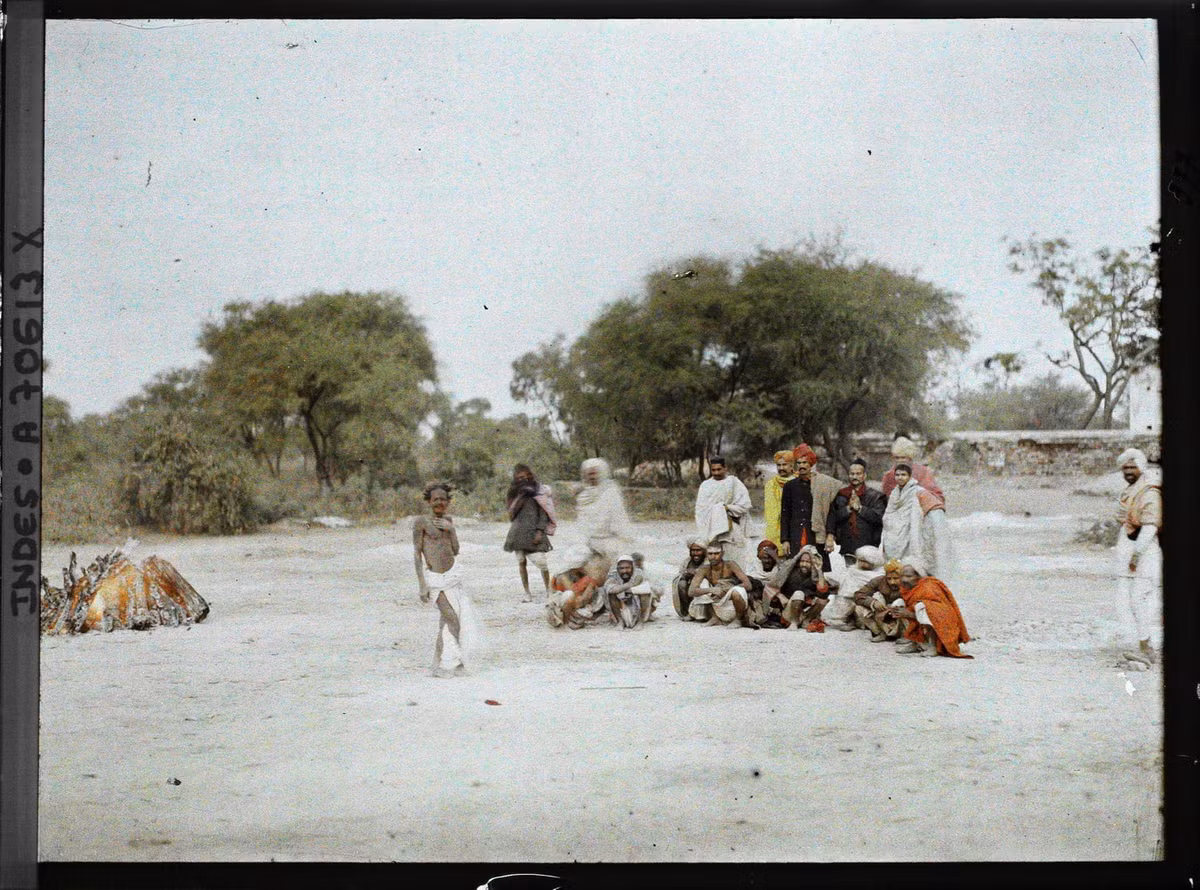 Những người đàn ông tham gia buổi hỏa táng theo kiểu truyền thống của đạo Hindu. Giàn thiêu đang cháy rực ở bên trái.