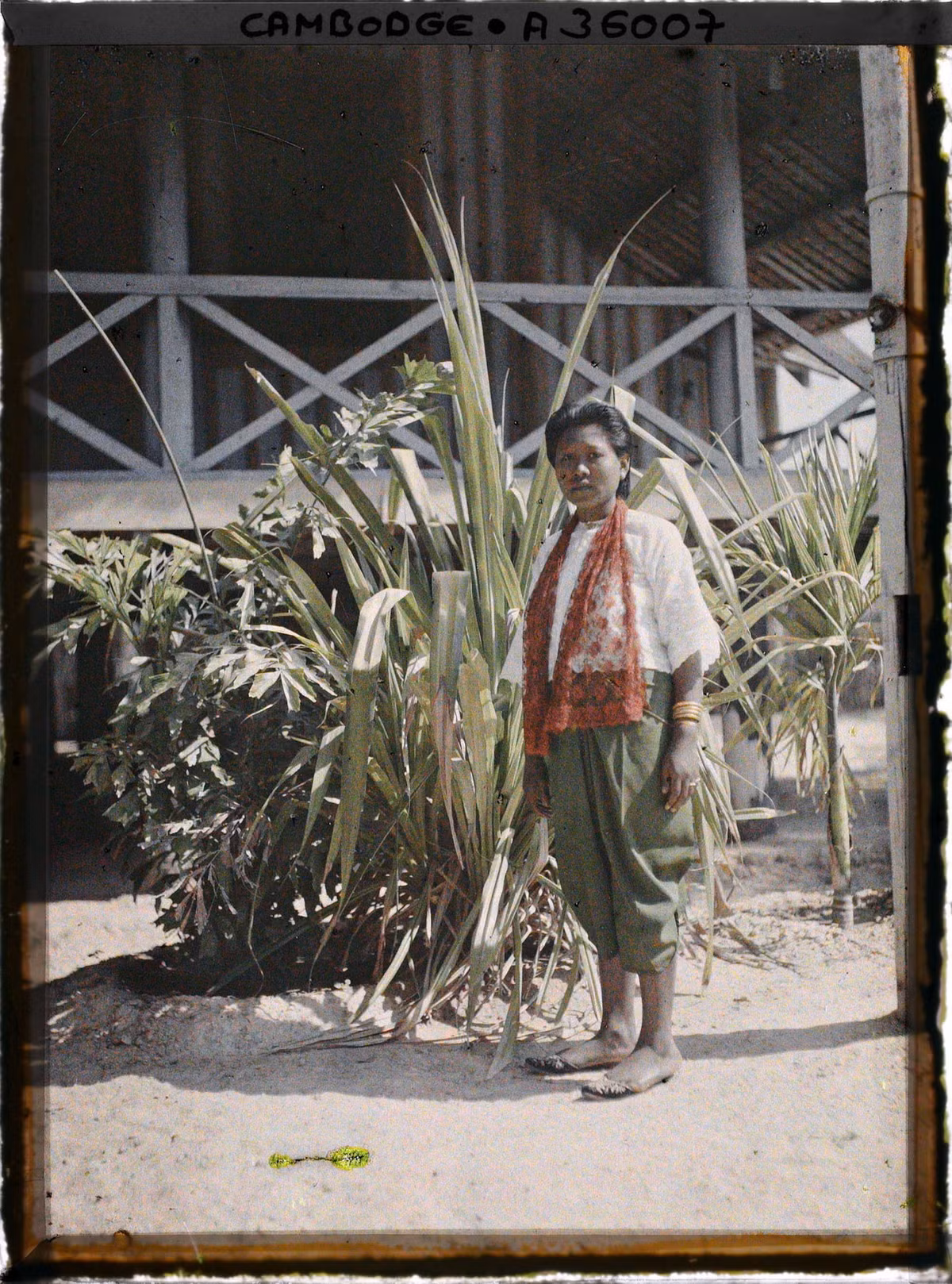 Người phụ nữ địa phương đứng bên ngôi nhà sàn.