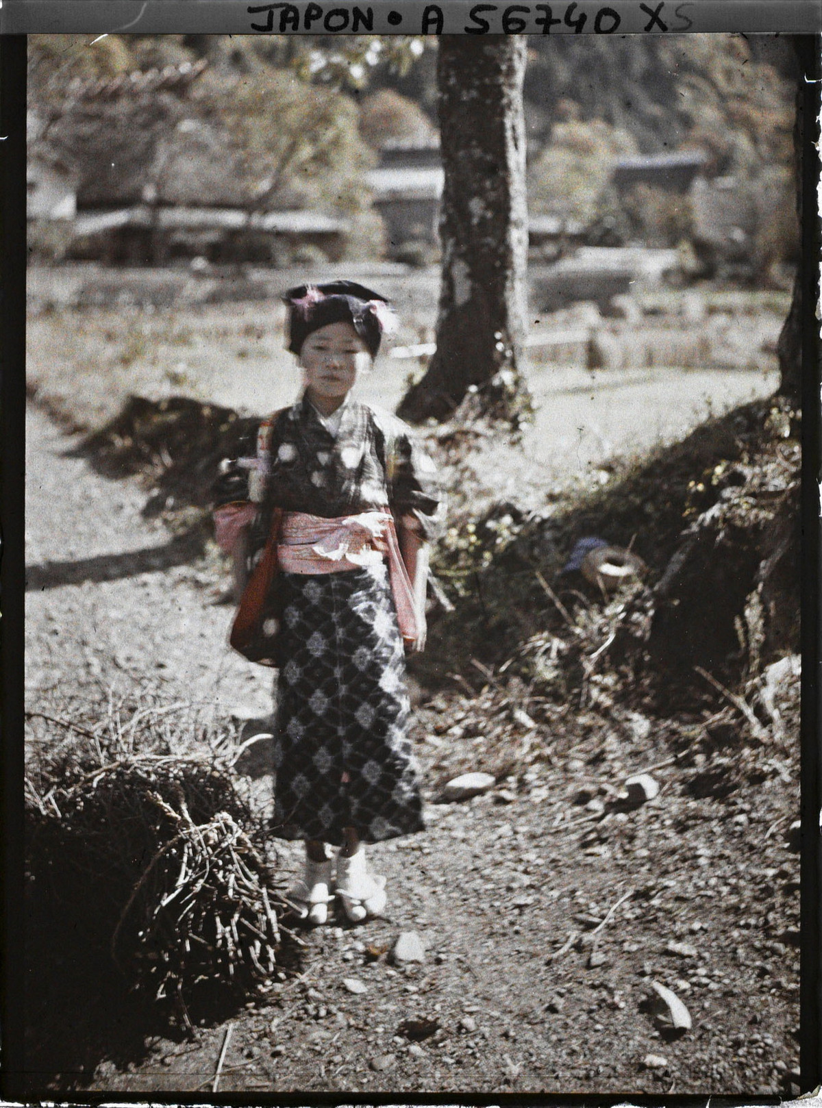 Cô gái nhỏ đứng trên đường làng.