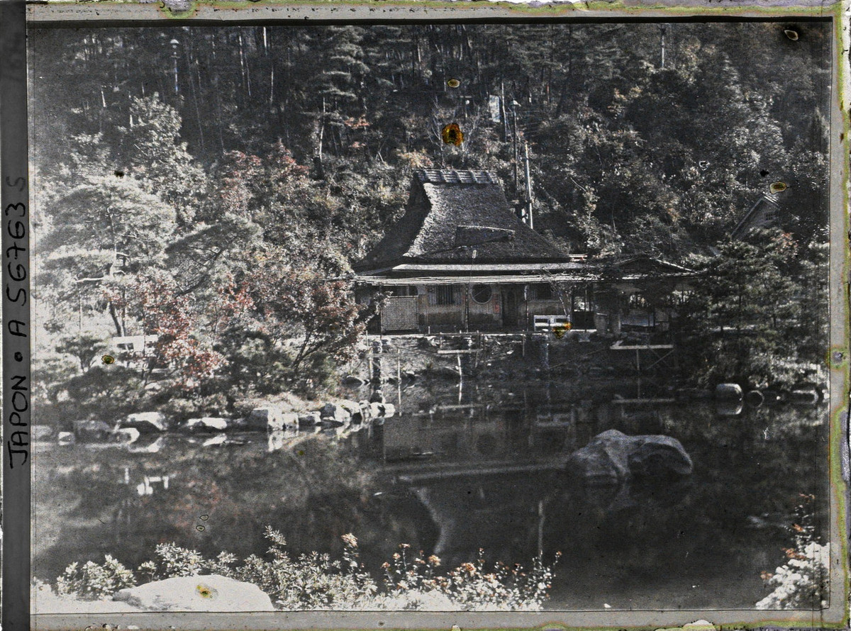 Ngôi nhà kiểu truyền thống soi bóng xuống ao nước.