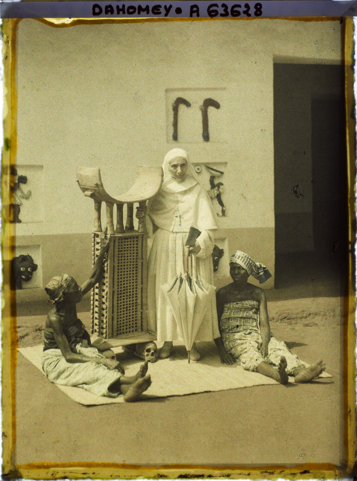 Mẹ Mélanie, bề trên của phái bộ Công giáo, đứng bên ngai vàng của vua Ghezo, hai bên là hai người phụ nữ bản địa.